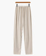 Beige casual loose fit pants with elastic waistband hanging on wooden hanger