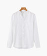 White long sleeve shirt with mandarin collar and front pocket hanging on wooden hanger